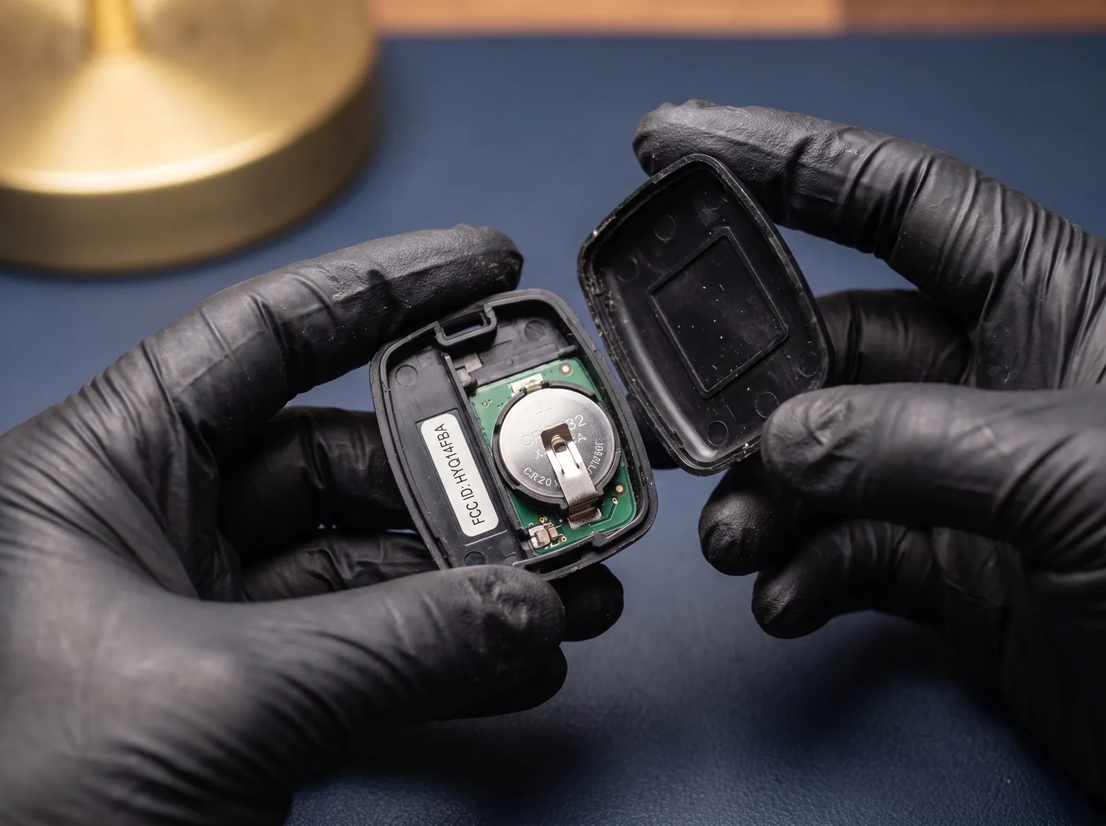 Opened key fob showing the coin cell battery and the FCC ID label inside the case